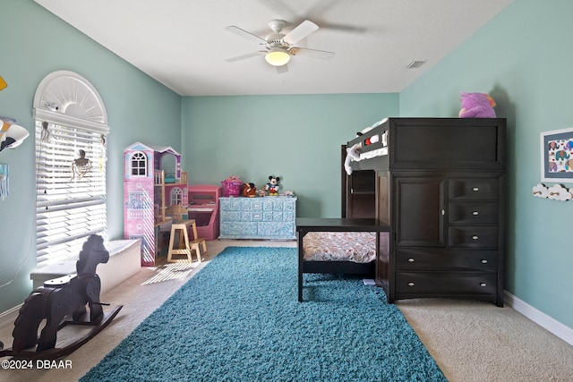 carpeted bedroom with multiple windows and ceiling fan