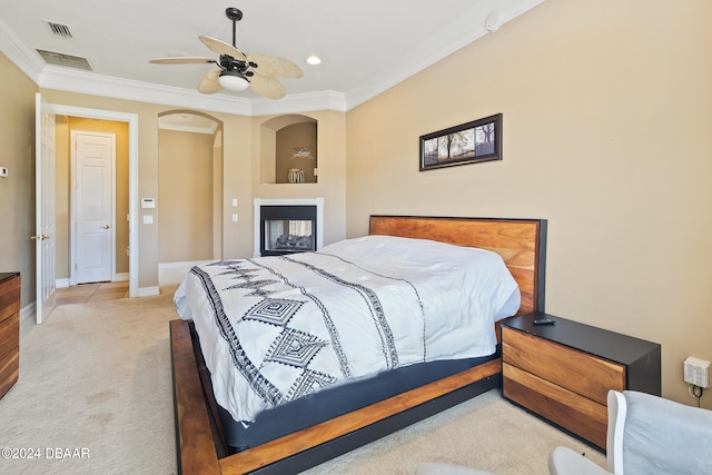 carpeted bedroom with ornamental molding and ceiling fan