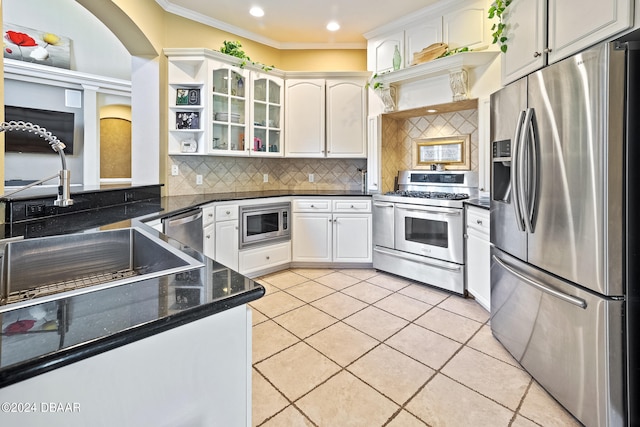 kitchen with sink, appliances with stainless steel finishes, ornamental molding, white cabinets, and decorative backsplash