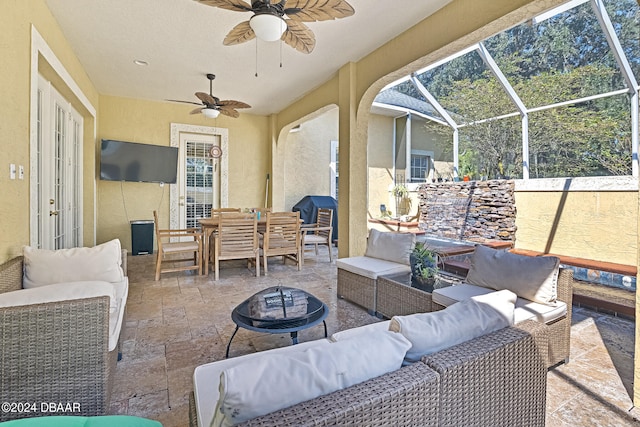 view of patio / terrace featuring an outdoor living space with a fire pit, area for grilling, a lanai, and ceiling fan