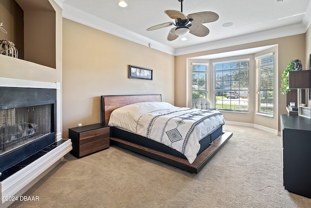 carpeted bedroom with ceiling fan, a textured ceiling, and ornamental molding