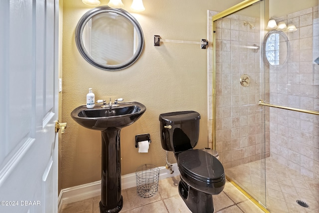 bathroom featuring a shower with shower door, tile patterned flooring, and toilet