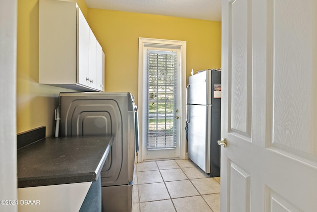 laundry area with washer / clothes dryer and light tile patterned flooring