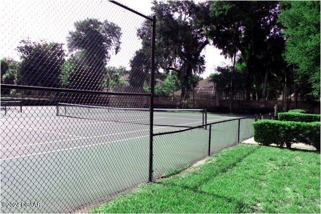 view of sport court featuring a lawn