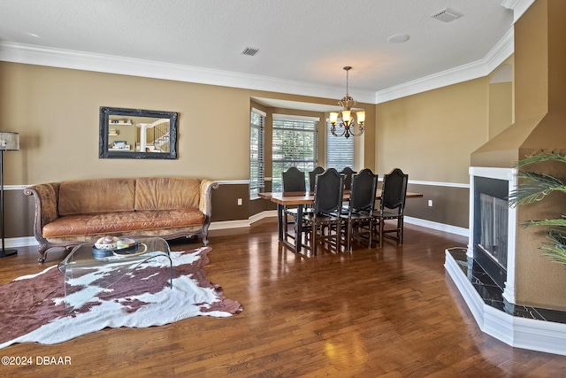 dining space featuring a chandelier, a textured ceiling, dark hardwood / wood-style flooring, and ornamental molding