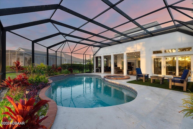 pool at dusk with glass enclosure, an in ground hot tub, and a patio