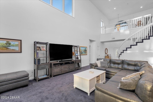 living room featuring a high ceiling and dark colored carpet