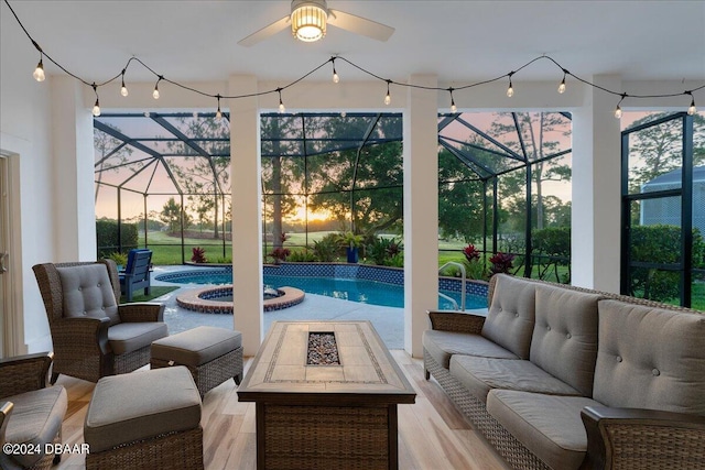 patio terrace at dusk featuring a lanai and an outdoor living space with a fire pit