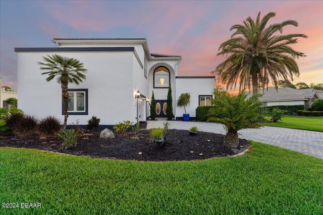 mediterranean / spanish house featuring a yard