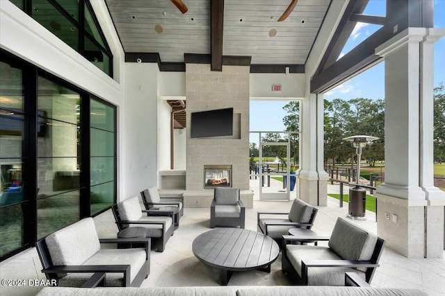 view of patio / terrace with an outdoor living space with a fireplace and ceiling fan