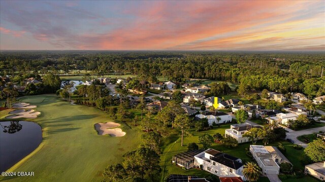 aerial view at dusk featuring a water view