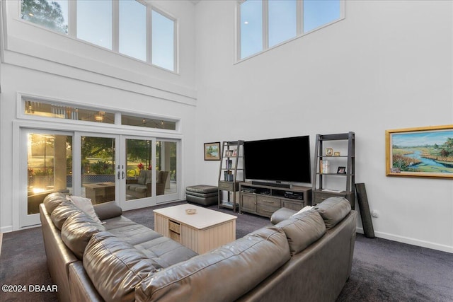 living room featuring french doors, a towering ceiling, and a healthy amount of sunlight