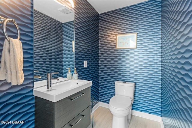 bathroom featuring wood-type flooring, vanity, and toilet