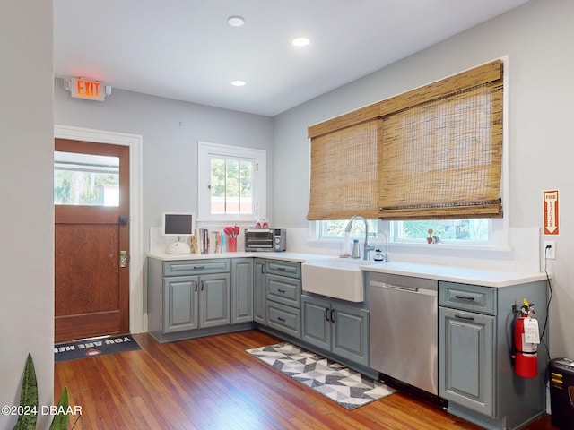 kitchen featuring gray cabinets, sink, stainless steel dishwasher, and plenty of natural light