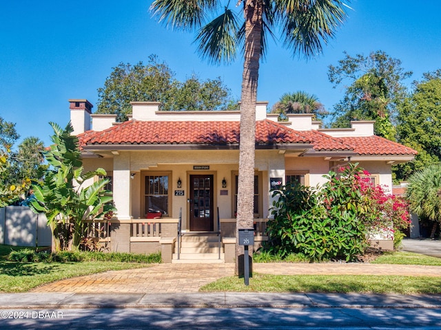 mediterranean / spanish house featuring covered porch