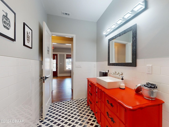 bathroom with tile patterned flooring, vanity, and tile walls