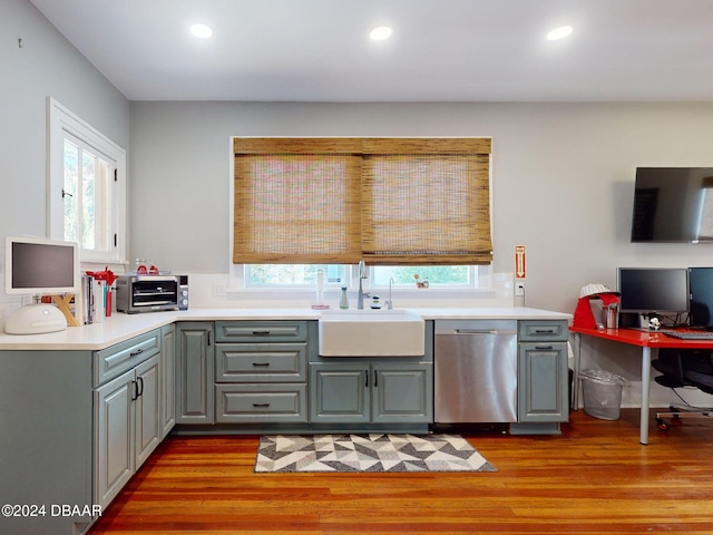 kitchen with dishwasher, sink, a wealth of natural light, and light hardwood / wood-style flooring