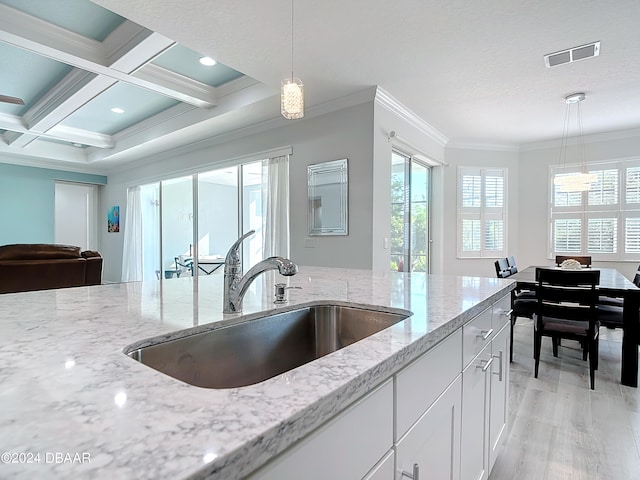 kitchen featuring white cabinets, plenty of natural light, sink, and pendant lighting