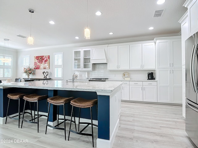 kitchen with an island with sink, plenty of natural light, and pendant lighting