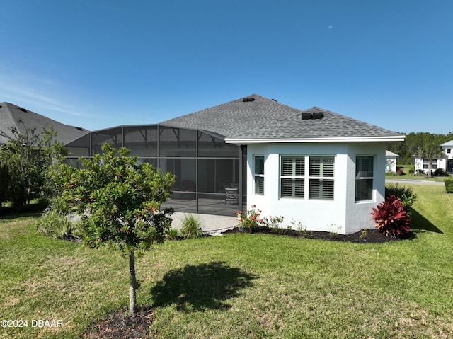 rear view of property featuring a yard and a lanai