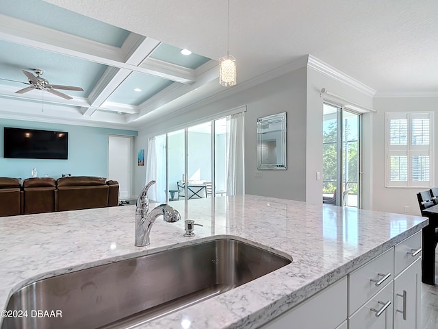 kitchen with white cabinetry, coffered ceiling, hanging light fixtures, sink, and beamed ceiling