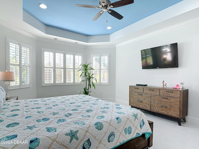 bedroom with ornamental molding, multiple windows, ceiling fan, and a raised ceiling