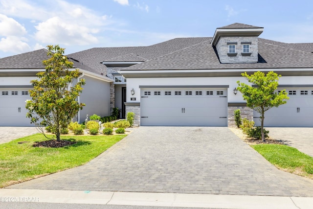 110 Longridge Ln, Ormond Beach, FL 32174 - view of front of house with roof with shingles, stucco siding, stone siding, decorative driveway, and a front yard