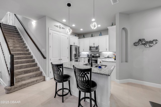 110 Longridge Ln, Ormond Beach, FL 32174 - kitchen featuring stainless steel appliances, a kitchen island with sink, backsplash, light stone counters, and recessed lighting
