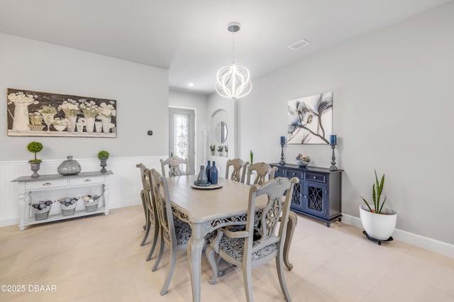 110 Longridge Ln, Ormond Beach, FL 32174 - dining space with a chandelier, wainscoting, and light tile patterned floors