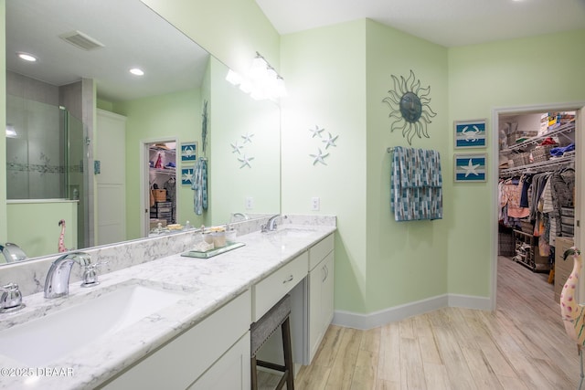 bathroom featuring vanity, wood-type flooring, and walk in shower