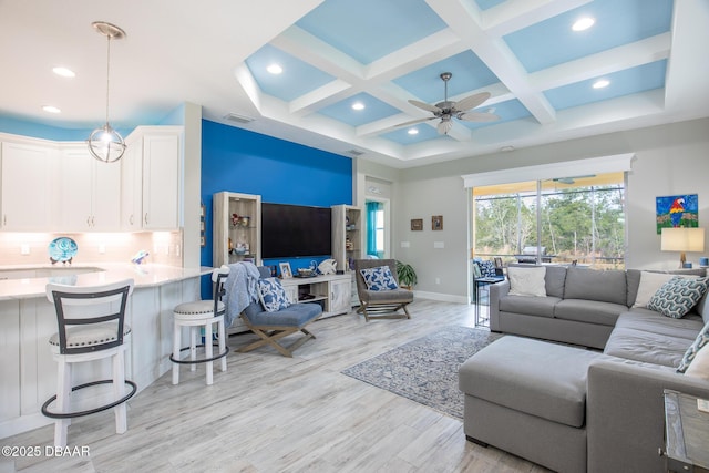 living room featuring ceiling fan, coffered ceiling, beam ceiling, and light hardwood / wood-style flooring