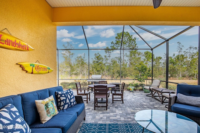 view of patio with outdoor lounge area and glass enclosure