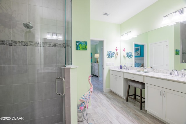 bathroom featuring vanity, wood-type flooring, and walk in shower