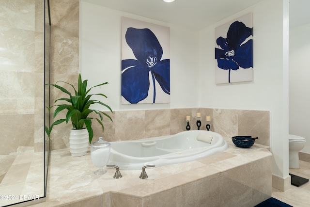 bathroom with tiled bath, tile patterned floors, and toilet