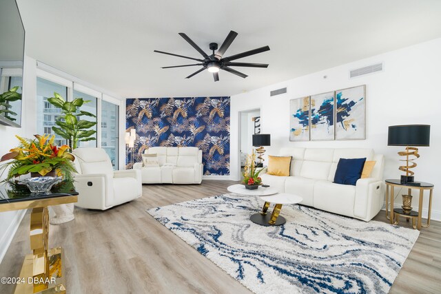 living room with ceiling fan and light hardwood / wood-style flooring