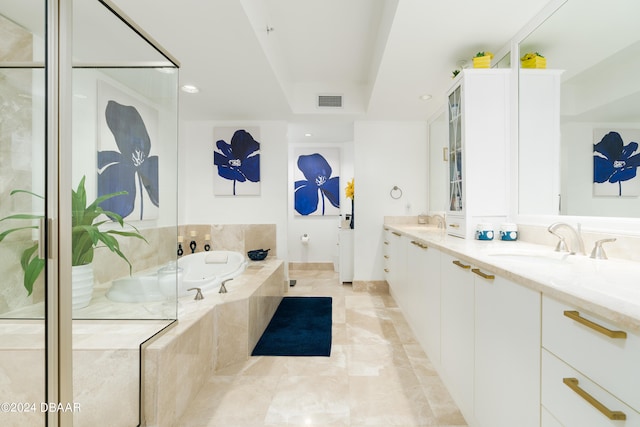 bathroom with vanity and tiled tub