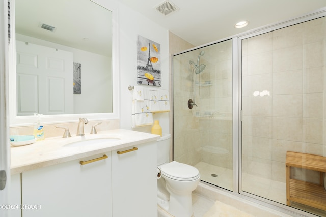 bathroom featuring vanity, toilet, and a shower with door