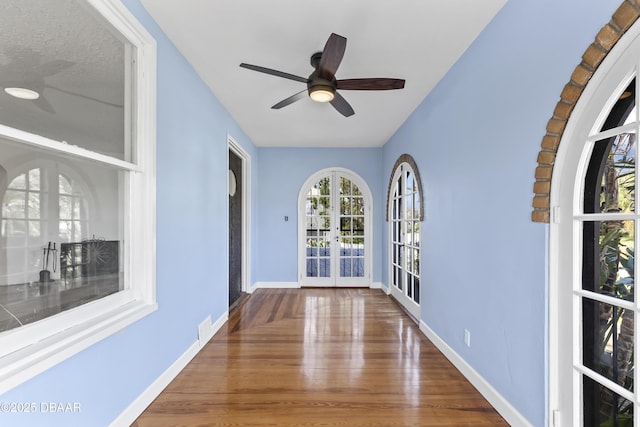 spare room featuring french doors, wood finished floors, visible vents, and baseboards