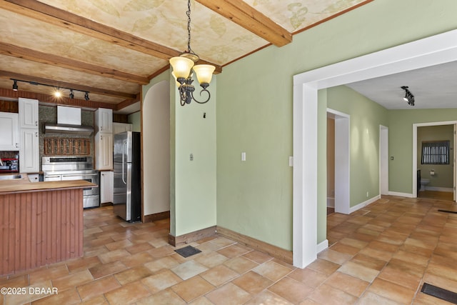kitchen featuring white cabinets, wall chimney exhaust hood, butcher block counters, appliances with stainless steel finishes, and pendant lighting