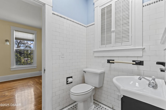 bathroom featuring toilet, tile walls, and vanity