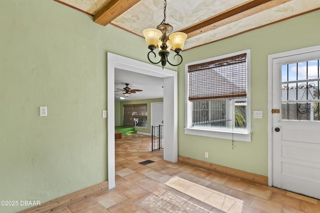 unfurnished dining area featuring visible vents, beamed ceiling, baseboards, and ceiling fan with notable chandelier