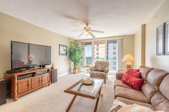 living room with ceiling fan, light colored carpet, and a textured ceiling