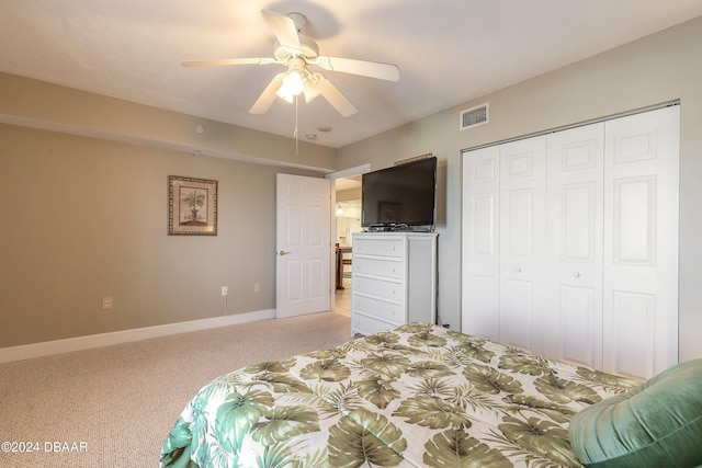 bedroom with ceiling fan, a closet, and light carpet