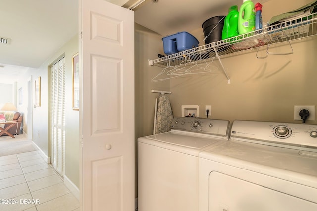 clothes washing area featuring light tile patterned floors and independent washer and dryer