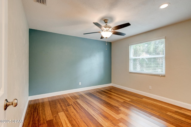 empty room with ceiling fan and hardwood / wood-style floors