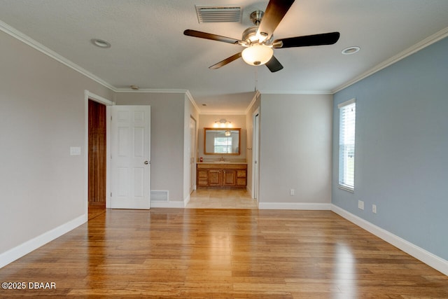 unfurnished room with crown molding, sink, and light hardwood / wood-style floors