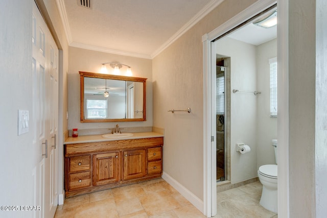 bathroom featuring crown molding, vanity, toilet, and a wealth of natural light