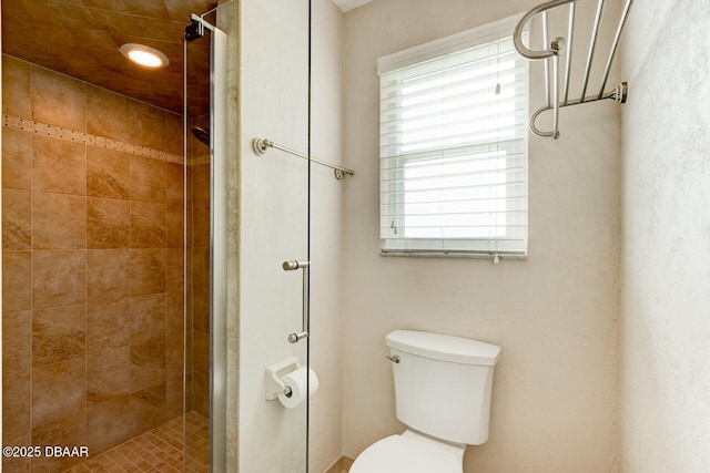 bathroom featuring toilet and a shower with shower door