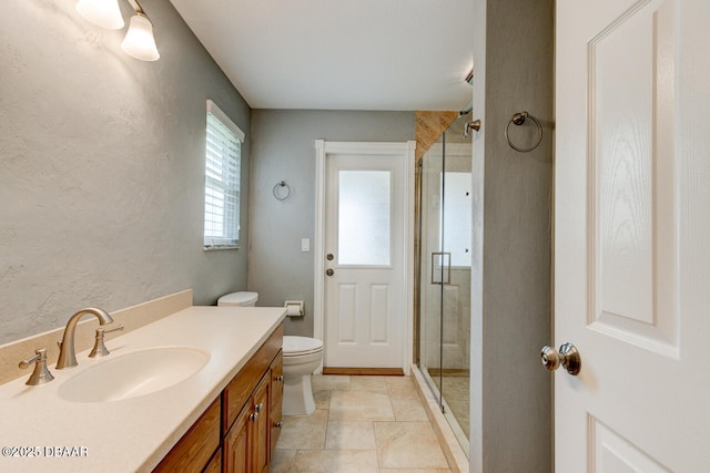 bathroom featuring vanity, toilet, and a shower with shower door