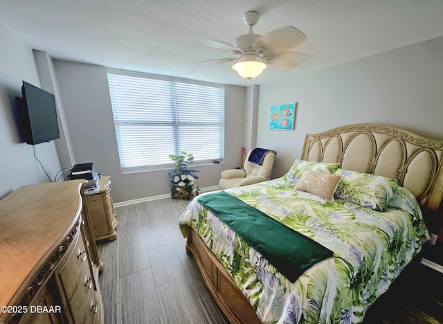 bedroom with hardwood / wood-style floors, a textured ceiling, and ceiling fan